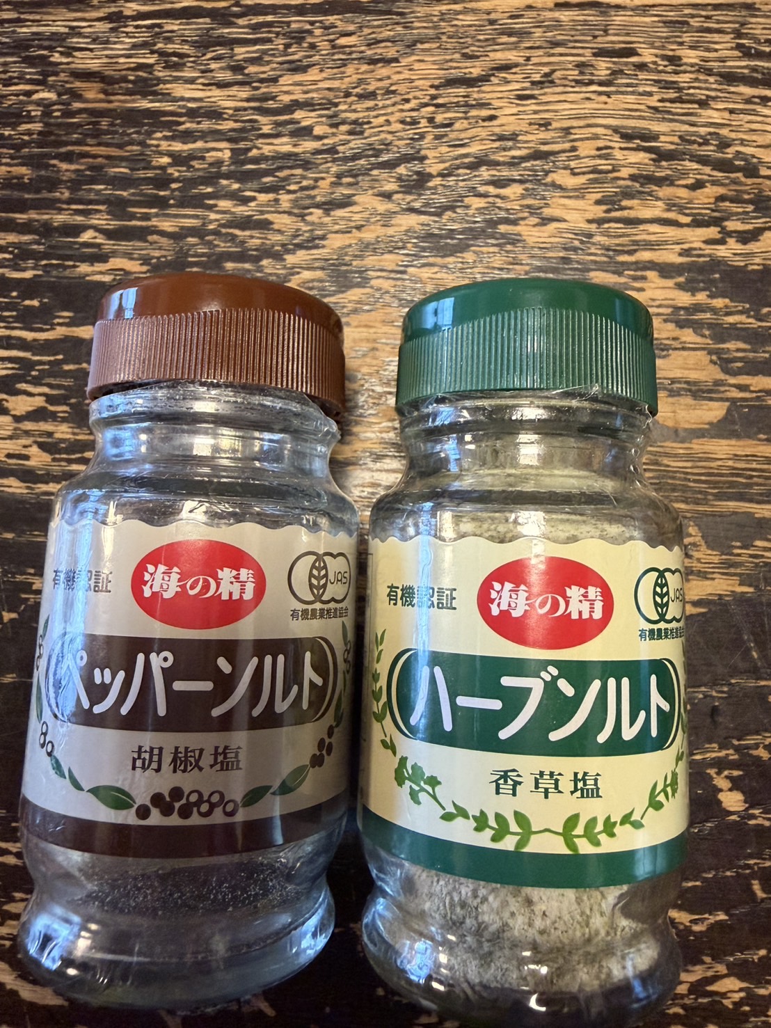 海の精のペッパーソルトとハーブソルトのボトルが並ぶ様子、有機JASマークの見えるラベル